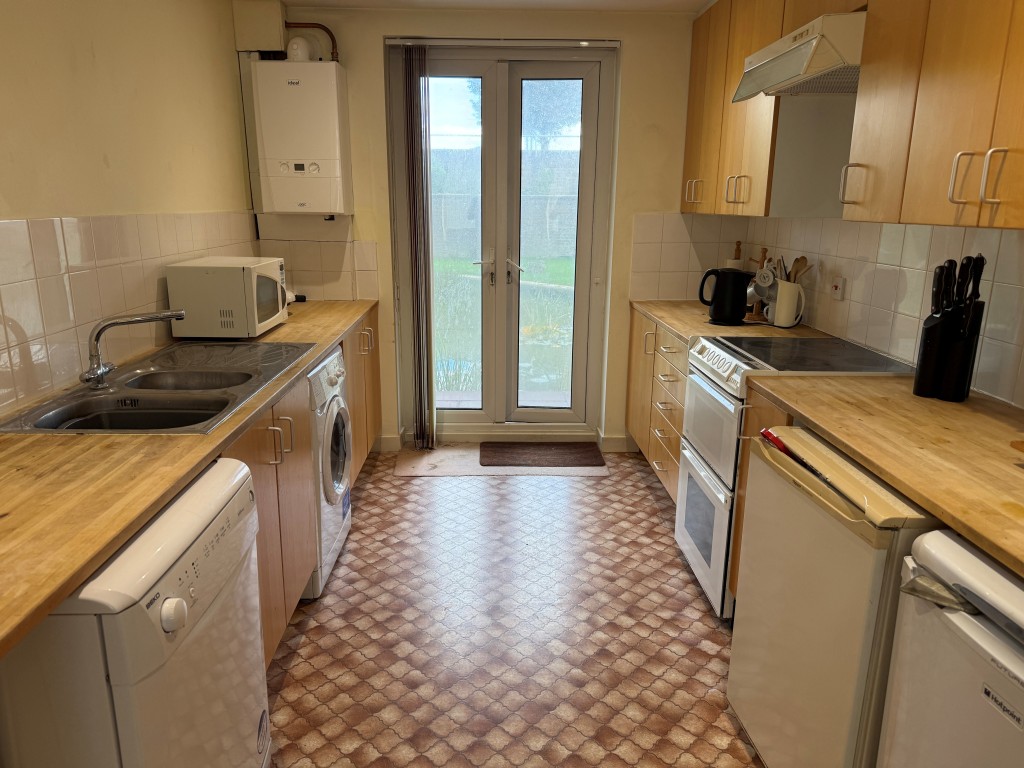 Lot: 130 - TWO-BEDROOM GROUND FLOOR FLAT IN NEED OF UPDATING CLOSE TO SEAFRONT - Kitchen with glazed doors to communal gardens